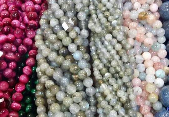 Numerosas piedras naturales cortadas en forma de pequeñas esferas de diversos colores acomodadas en distintos hilos
